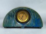 a blue and yellow clock sitting on top of a table