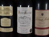 three bottles of wine are lined up on a table