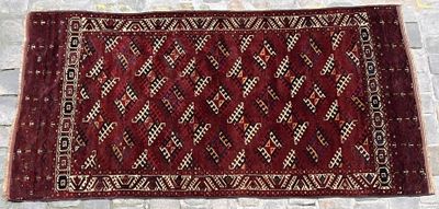 a close up of a red rug on a brick floor