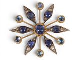 an image of a broochle with blue stones and gold