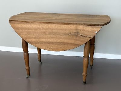 une petite table avec un plateau en bois, montée sur roulettes