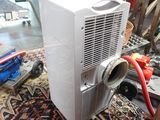 a small air conditioner sitting on a rug on the floor
