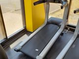 two tread machines in a gym room with a view out the window