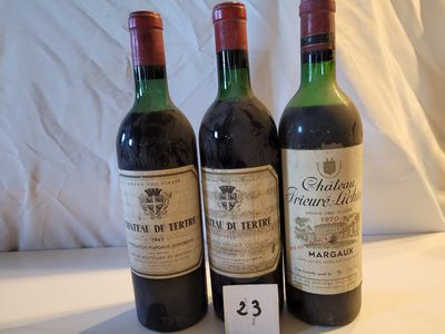 Trois bouteilles de vin sont posées sur une table, accompagnées d'une étiquette de prix