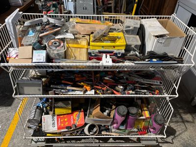 a metal cart filled with assorted items on the street