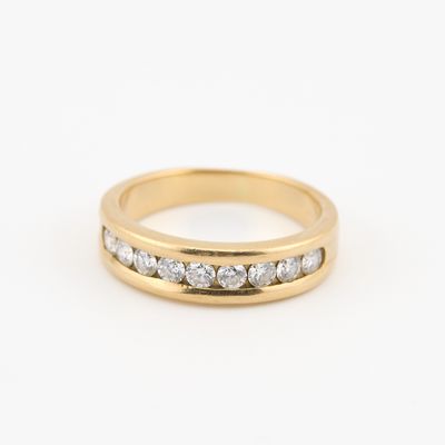 une bague en or jaune sertie de trois diamants sur fond blanc