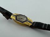 an image of a wrist watch with a black strap and a gold plated watch face