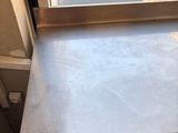 a metal table with a metal top in front of a window