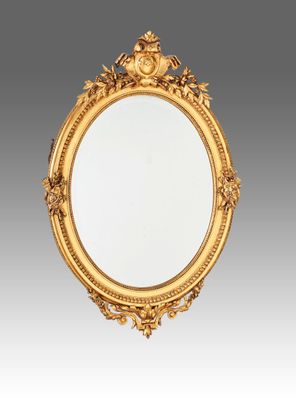 un miroir à cadre doré orné d'une tête de lion dans sa partie supérieure