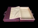 an open book sitting on top of a purple case on a black surface
