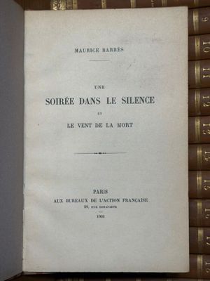 un livre ouvert posé sur une table à côté d'une pile de livres