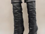 une paire de bottes en cuir noir sur fond blanc
