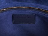 a close up of a blue purse with a black leather handle