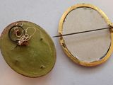 a picture of a brooch and a pin on a table