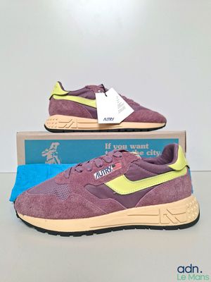 a pair of purple and yellow sneakers on a blue box
