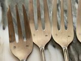 four forks that are sitting on a marble table