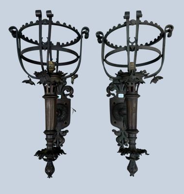 pair of antique wall sconces with ornate designs on each of them