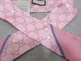 a pink neck tie with a blue and gold design on it