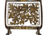 a close up of a metal plate with leaves and flowers on it