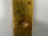 a gold bar sitting on top of a white surface