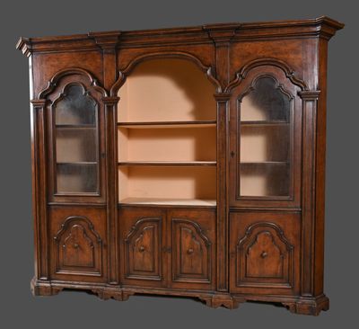 une bibliothèque ancienne en noyer, avec des portes vitrées et des étagères