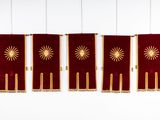three red and gold banners hanging from the ceiling of a room
