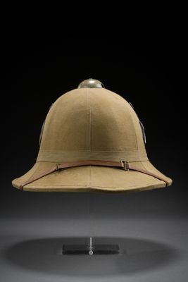 a helmet on a stand against a black background