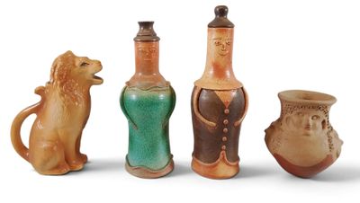 quatre vases de couleurs différentes sont alignés sur une surface blanche