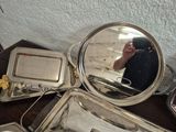 a table with a mirror, trays, and a cell phone on it