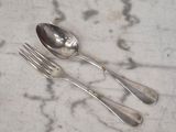une cuillère et une fourchette en argent posées sur une table en marbre