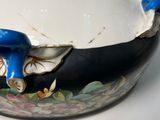 a black and white bowl with blue handles on a table