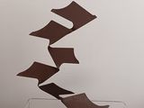 a sculpture made of brown paper on top of a clear box