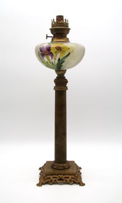 une lampe à l'ancienne, décorée de fleurs peintes sur fond blanc