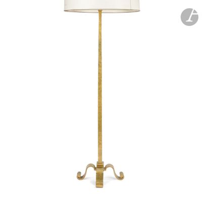un lampadaire doré muni d'un abat-jour blanc