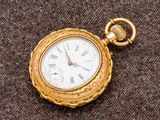 une montre de poche en or avec des chiffres romains
