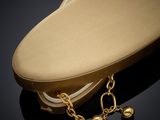 a gold purse with a chain around it on a black surface