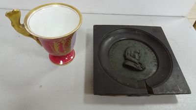 a cup and a plate on a table next to each other