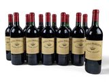 six bottles of red wine lined up in a row on a white surface