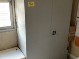 une armoire placée dans un coin d'une pièce dotée d'une fenêtre