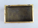 a small metal box with a handle on a white surface
