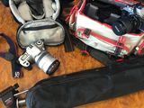 une table sur laquelle se trouvent un appareil photo, un étui pour appareil photo, un appareil photo et d'autres objets