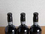 three bottles of wine sitting on a table next to each other