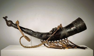 une grande corne surmontée d'une corde