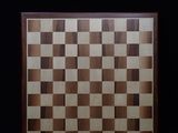 a picture of a wooden chess board on a black background