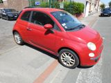 a small red car that is parked on the side of the street
