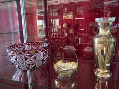 une vitrine en verre sur laquelle sont posés deux vases et un bol