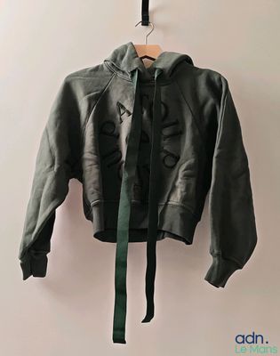 une veste suspendue à un cintre accroché au mur