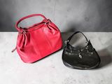 two purses sitting next to each other on top of a table