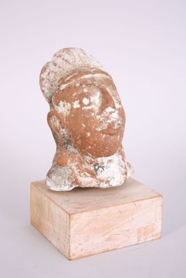 une image représentant une sculpture représentant une tête de femme posée sur un socle en bois