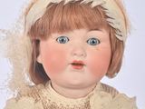 a doll that is wearing a sweater and a hat